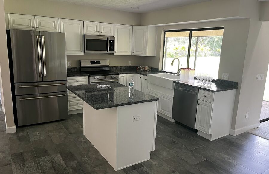Completed kitchen renovation with white cabinetry and island